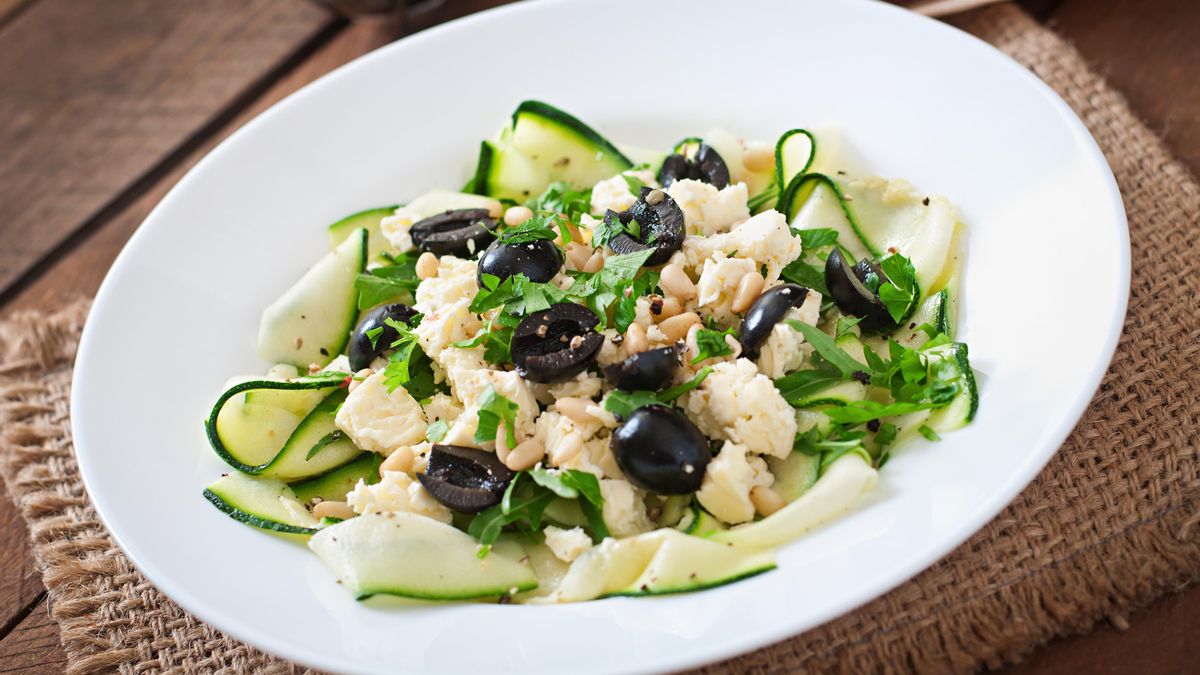 Ensalada mediterránea de cintas de calabacín marinado con queso feta, aceitunas negras y piñones