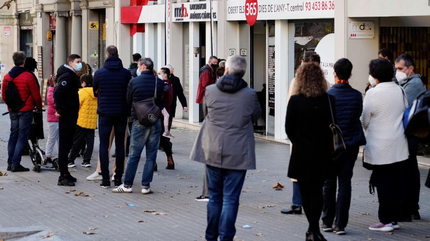 Varias personas hacen fila frente a un laboratorio de análisis clínicas para realizarse pruebas de antígenos y PCR este domingo de San Esteban en Barcelona. EFE/Enric Fontcuberta