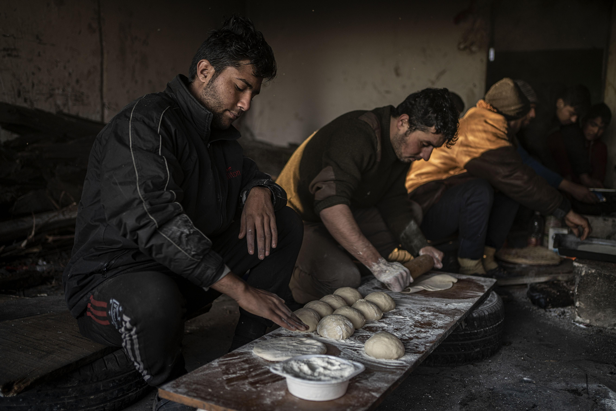 Todas las mañas el grupo de afganos que vive en la fábrica trabajan organizados para hacer pan y poder desayunar