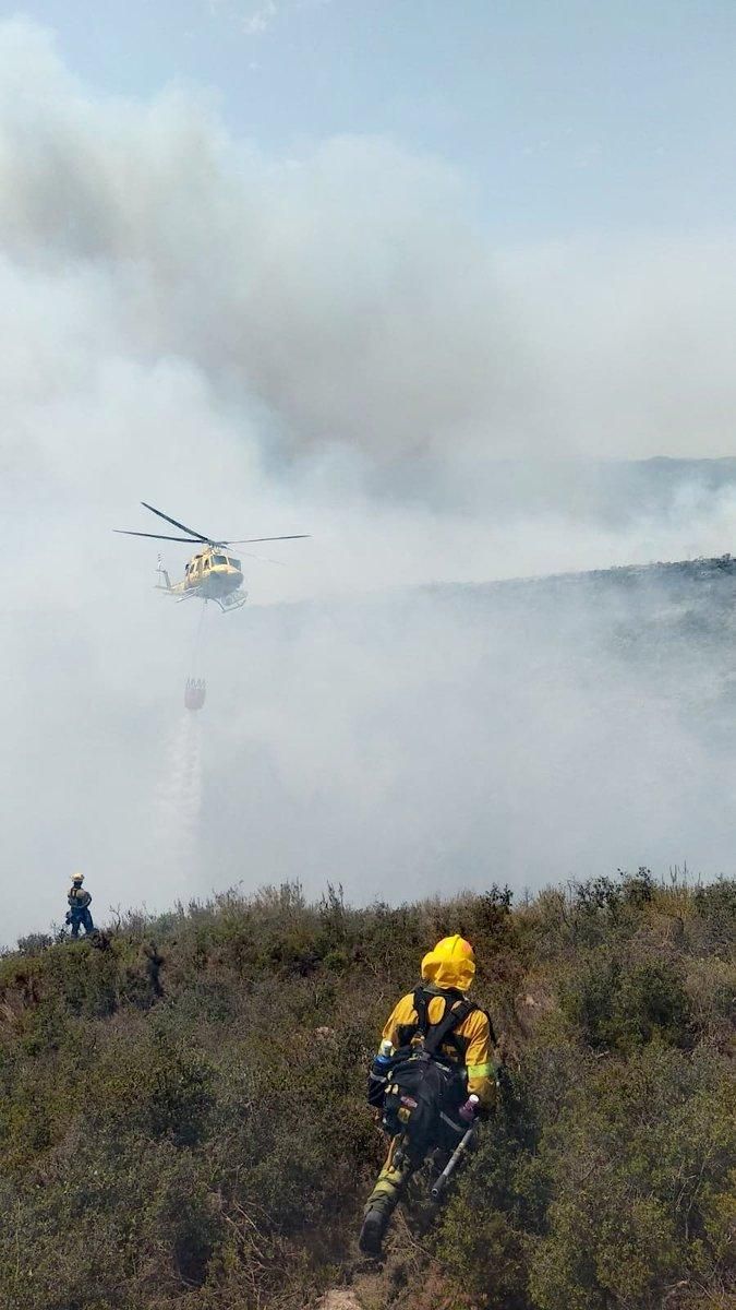 Un helicóptero descarga agua sobre la zona afectada