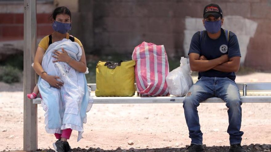 Dos personas esperan en un paradero de autobuses, en Tegucigalpa (Honduras).