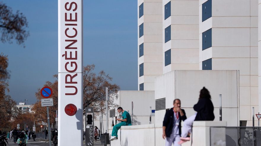 Personal sanitario del hospital La Fe de Valencia descansa a las puertas de urgencias del centro hospitalario. EFE/Manuel Bruque