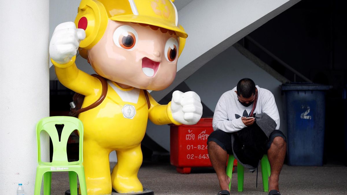 A person uses a mobile phone next to a cheerful sculpture during a COVID-19 vaccination drive for employees in service establishments and related businesses at a vaccination center in Bangkok, Thailand, 09 November 2021.