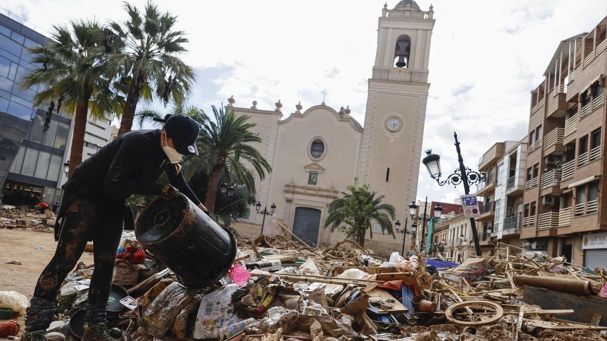 Un voluntario apila basura durante la limpieza de Paiporta tras el paso de la dana