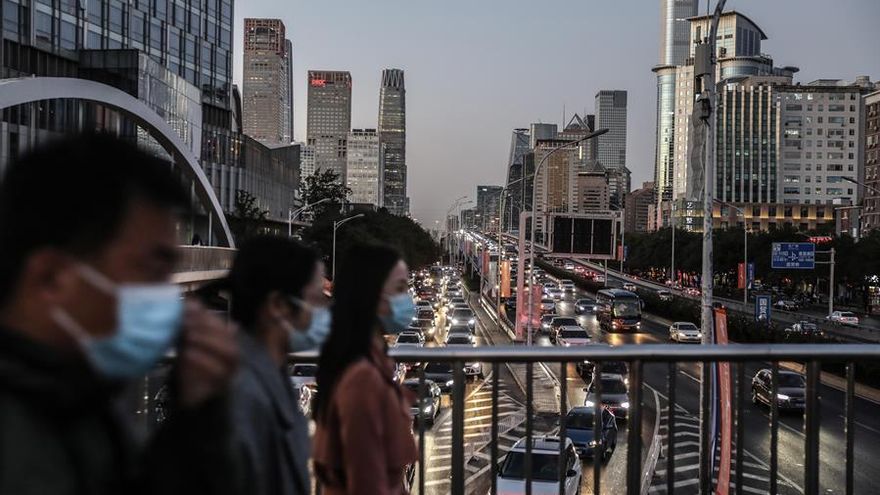 Vista de los coches que pasan por debajo de un puente peatonal en Pekín, China.