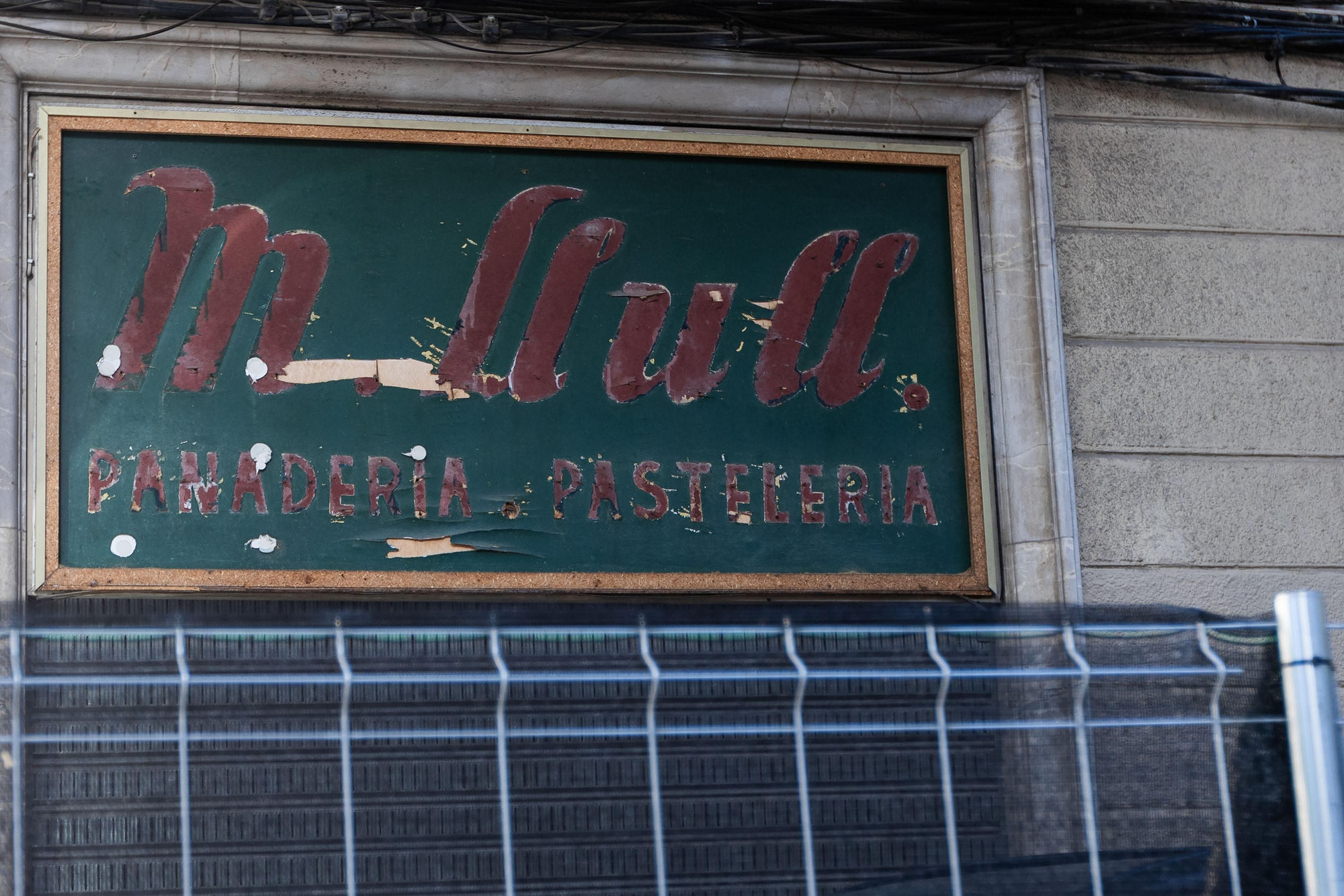 El rótulo de la histórica pastelería Llull, abierta en 1953 y clausurada en 2017, aún se conserva junto al edificio de Bennàzar de la calle 31 de desembre