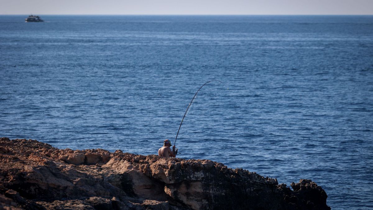 Un hombre pesca en Punta de sa Pedrera, a mar abierto.