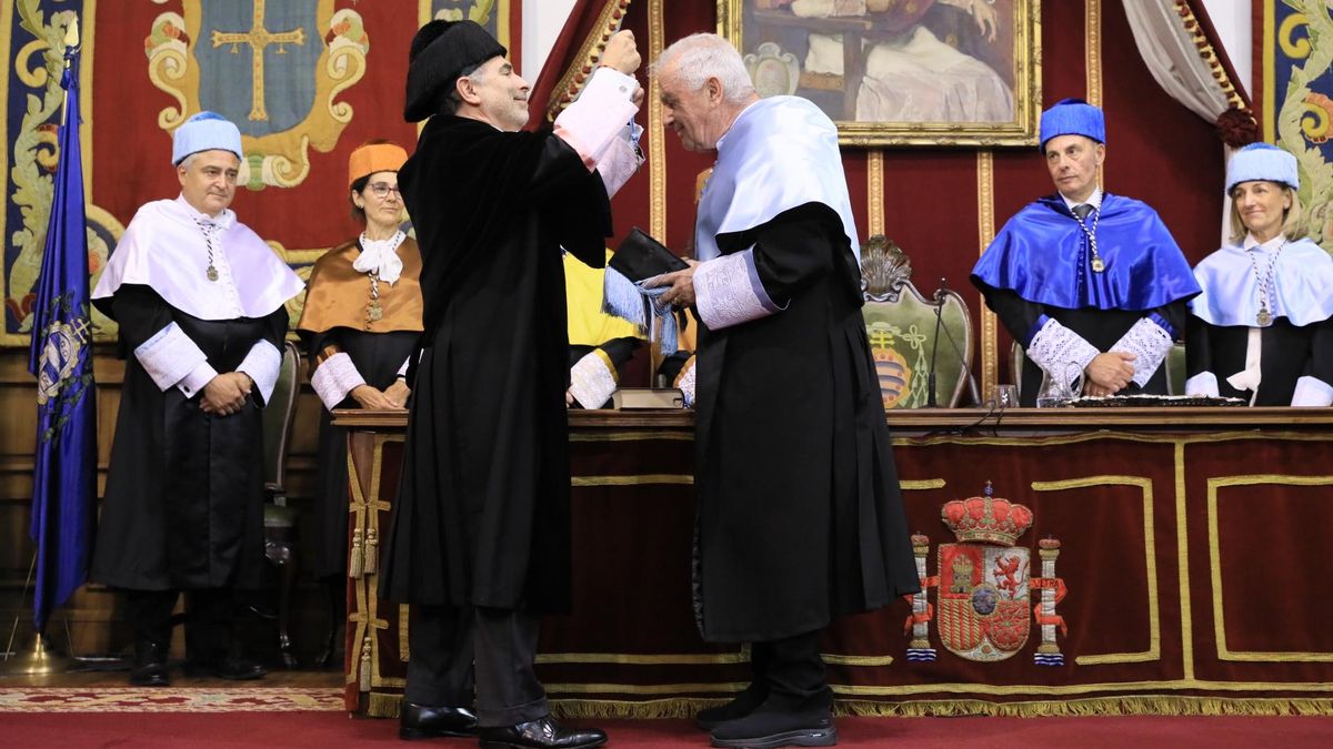 El rector, Ignacio Villaverde, coloca a Víctor Manuel los atributos que simbolizan su incorporación al claustro de doctores y doctoras de la Universidad de Oviedo.