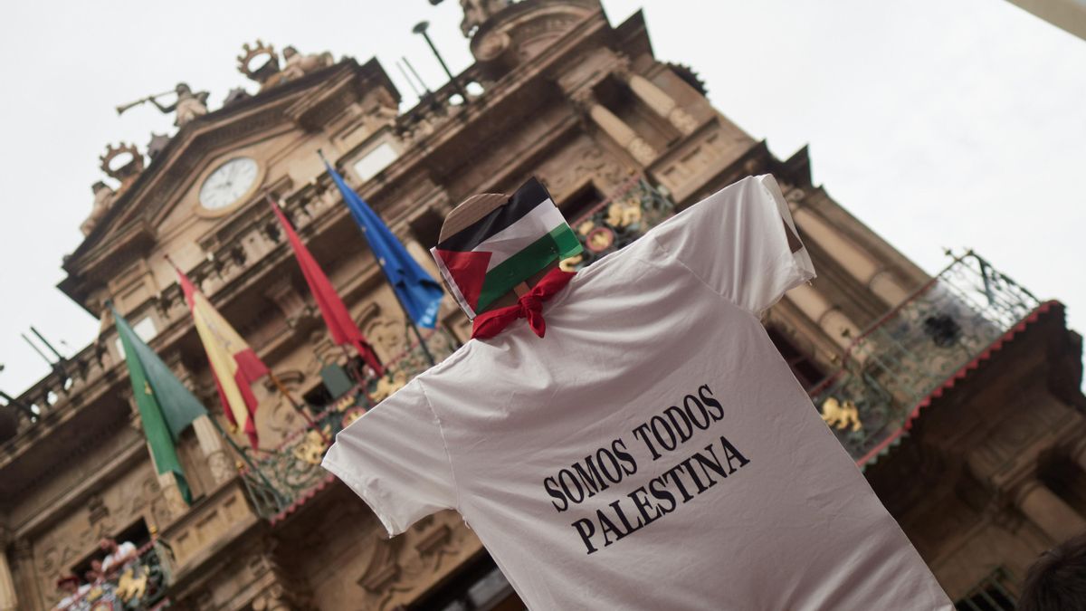 Una persona sujeta una camiseta con un mensaje de apoyo a Palestina en los instantes previos al lanzamiento del Chupinazo en Pamplona.