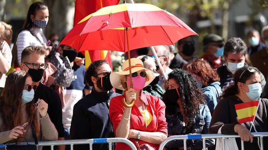 Una mujer, conjuntada con los colores de la bandera española, en los alrededores del Palacio Real