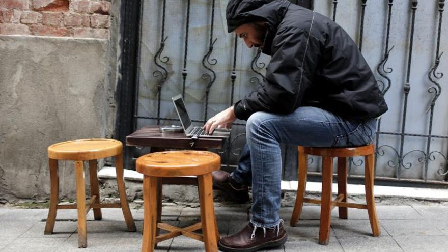 Un hombre navega por Internet en su ordenador portátil.