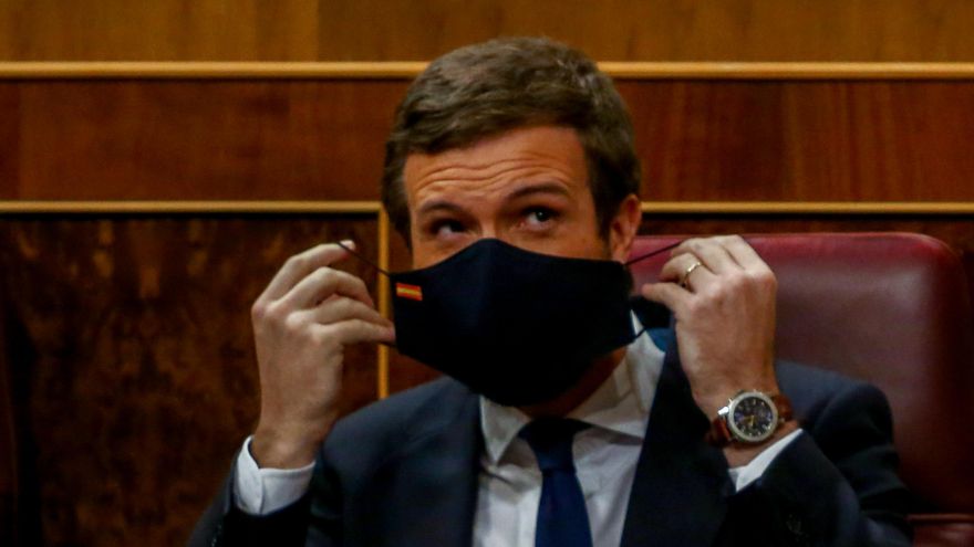 El líder del PP, Pablo Casado, se coloca la mascarilla durante una sesión plenaria