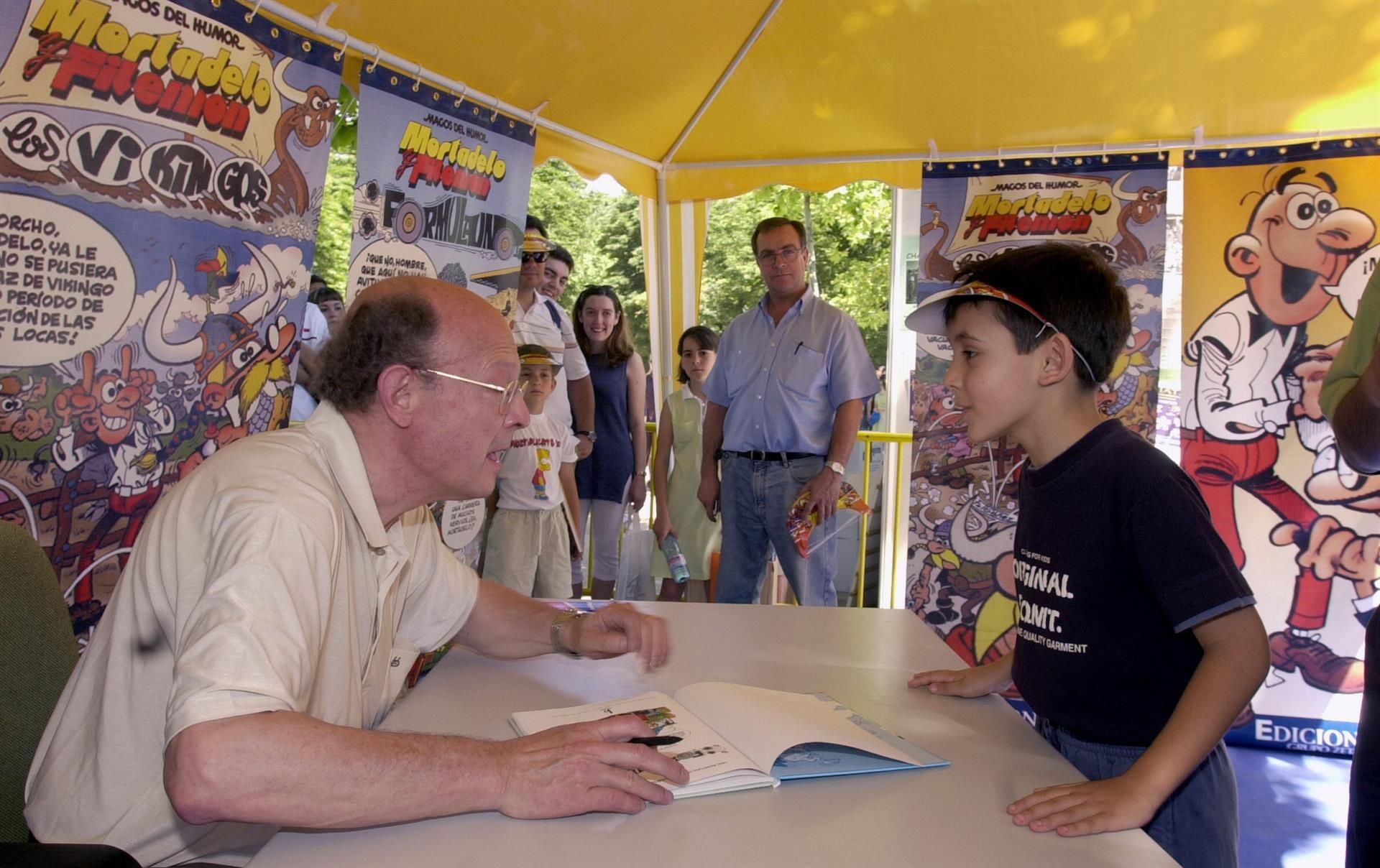 Francisco Ibáñez atiende a un niño en la Feria del Libro de Madrid