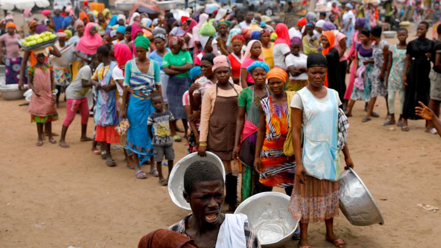 Personas haciendo fila para recibir alimentos y agua en Ghana