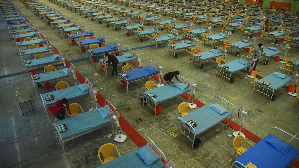 Indian health staff members arrange medical beds inside the Chennai Trade Centre (CTC) which is converted into a makeshift COVID-19 care facility for coronavirus patients following a sharp surge in cases, in Chennai, India, 16 January 2022.