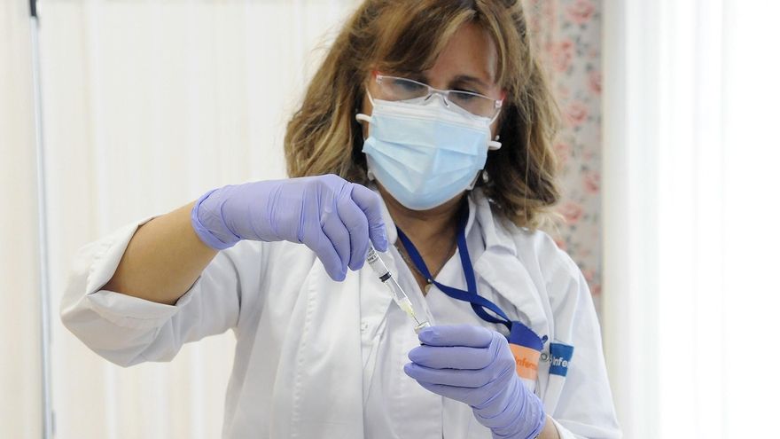 Enfermera preparando una vacuna contra la COVID.