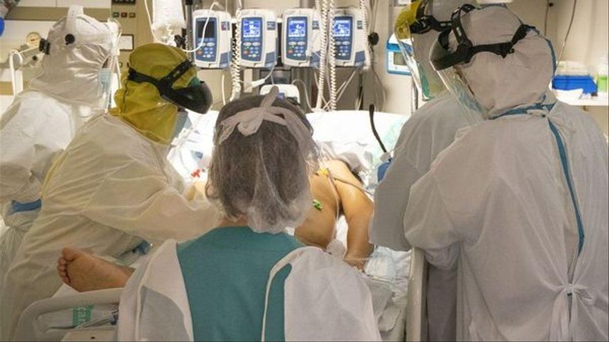 Personal sanitario atiende a un paciente de coronavirus en UCI
