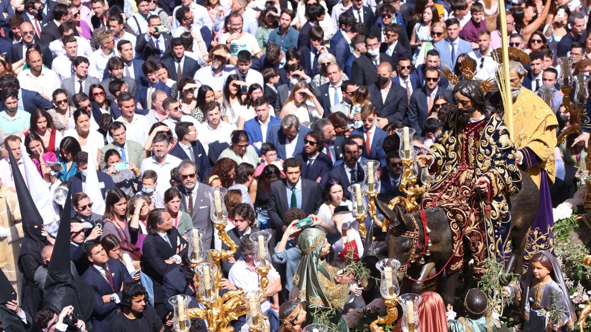 Un público mayoritariamente sin mascarilla contempla la Borriquita en Sevilla.