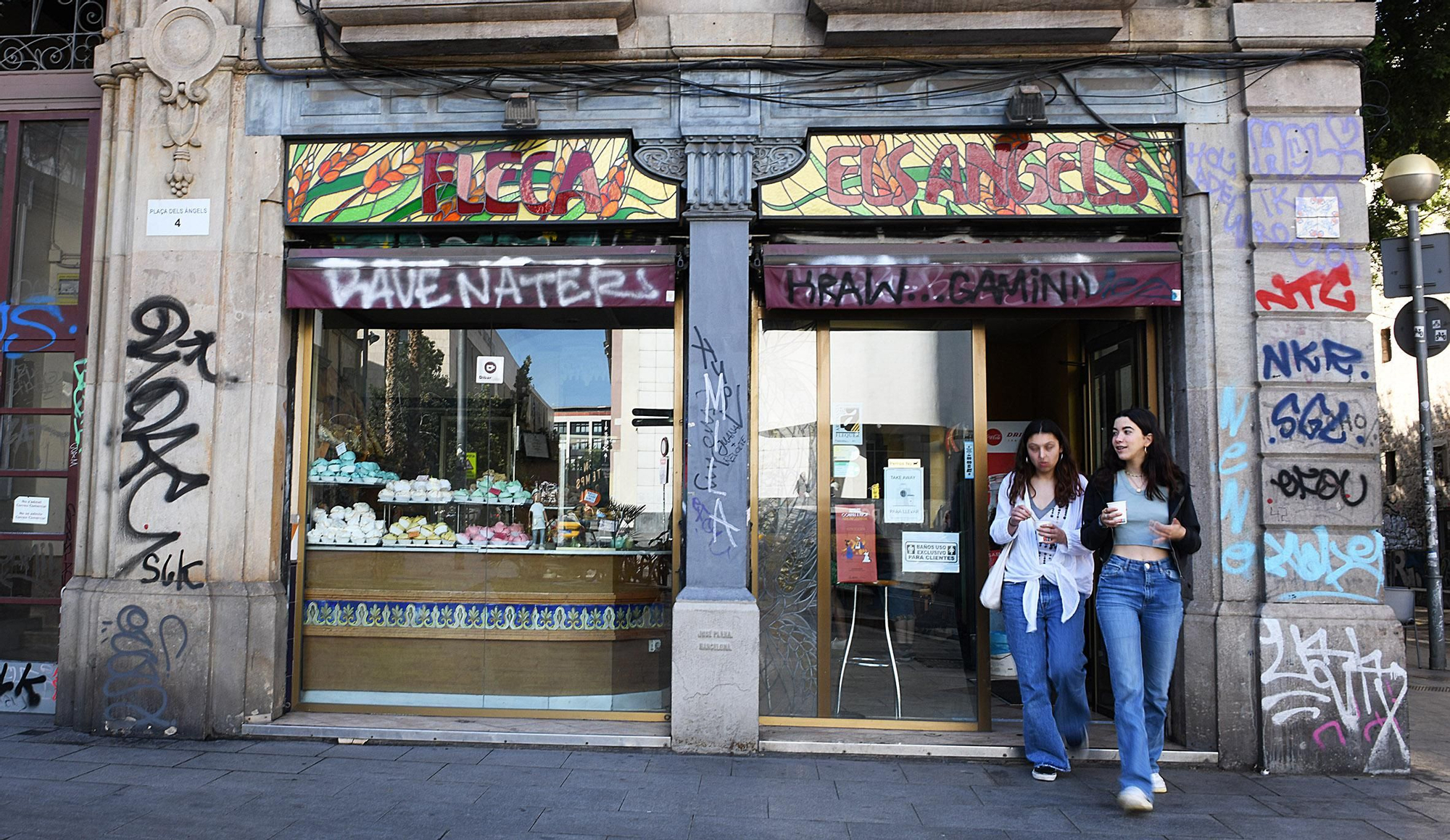 Dos turistas salen de uno de los locales del Raval