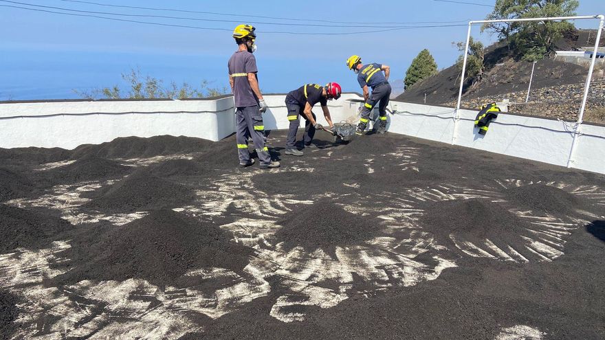 Bomberos de Gran Canaria retirando ceniza de una azotea en La Palma