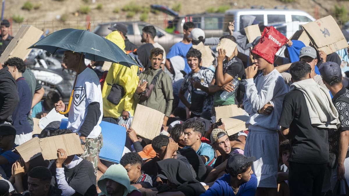 Migrantes esperan en una cola, a 24 de agosto de 2026, en Ceuta