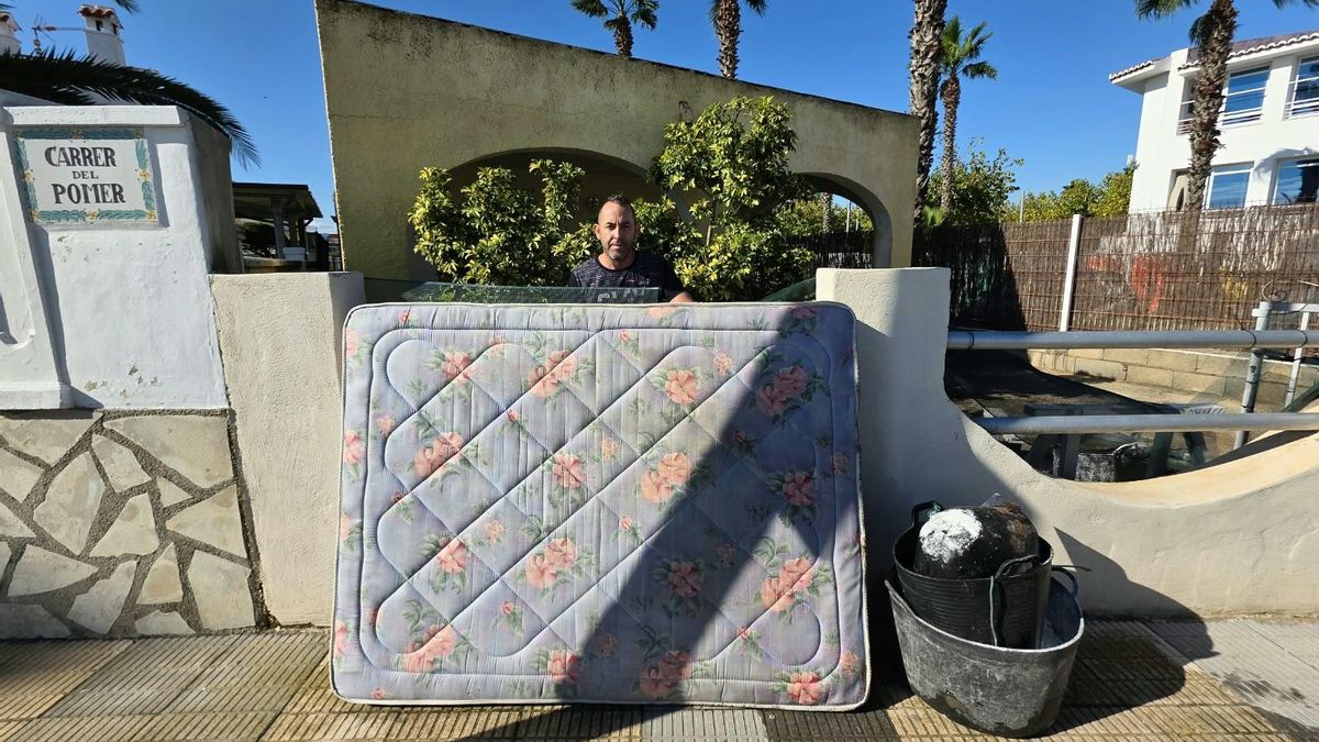 Raúl delante de su casa, con los colchones que usaron para ponerse a salvo del agua.