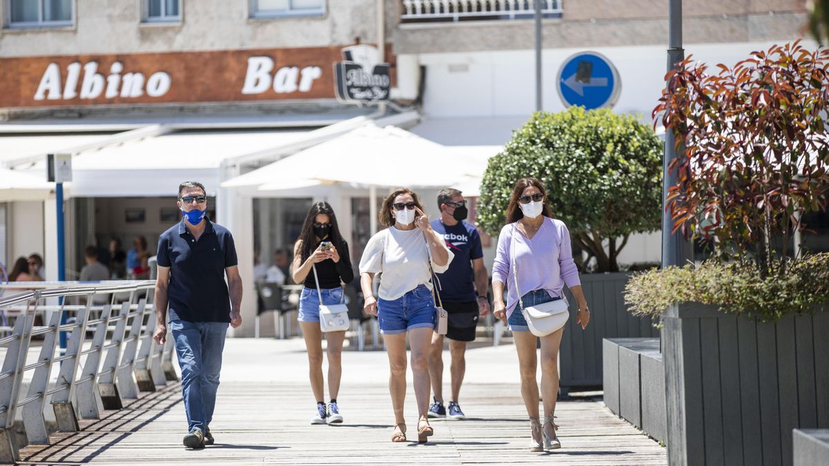 Varias personas caminan con mascarilla