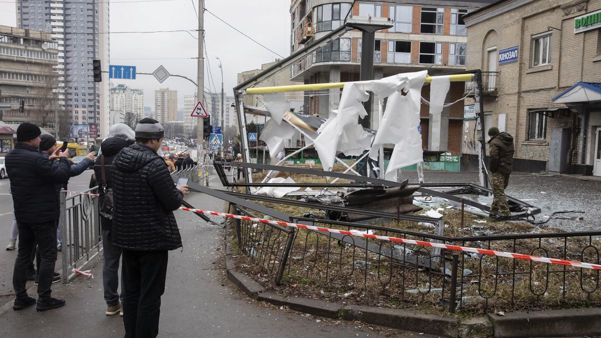 Personas se reúnen alrededor de los restos de un objeto no identificado tras una explosión en Kiev, el 24 de febrero de 2022.