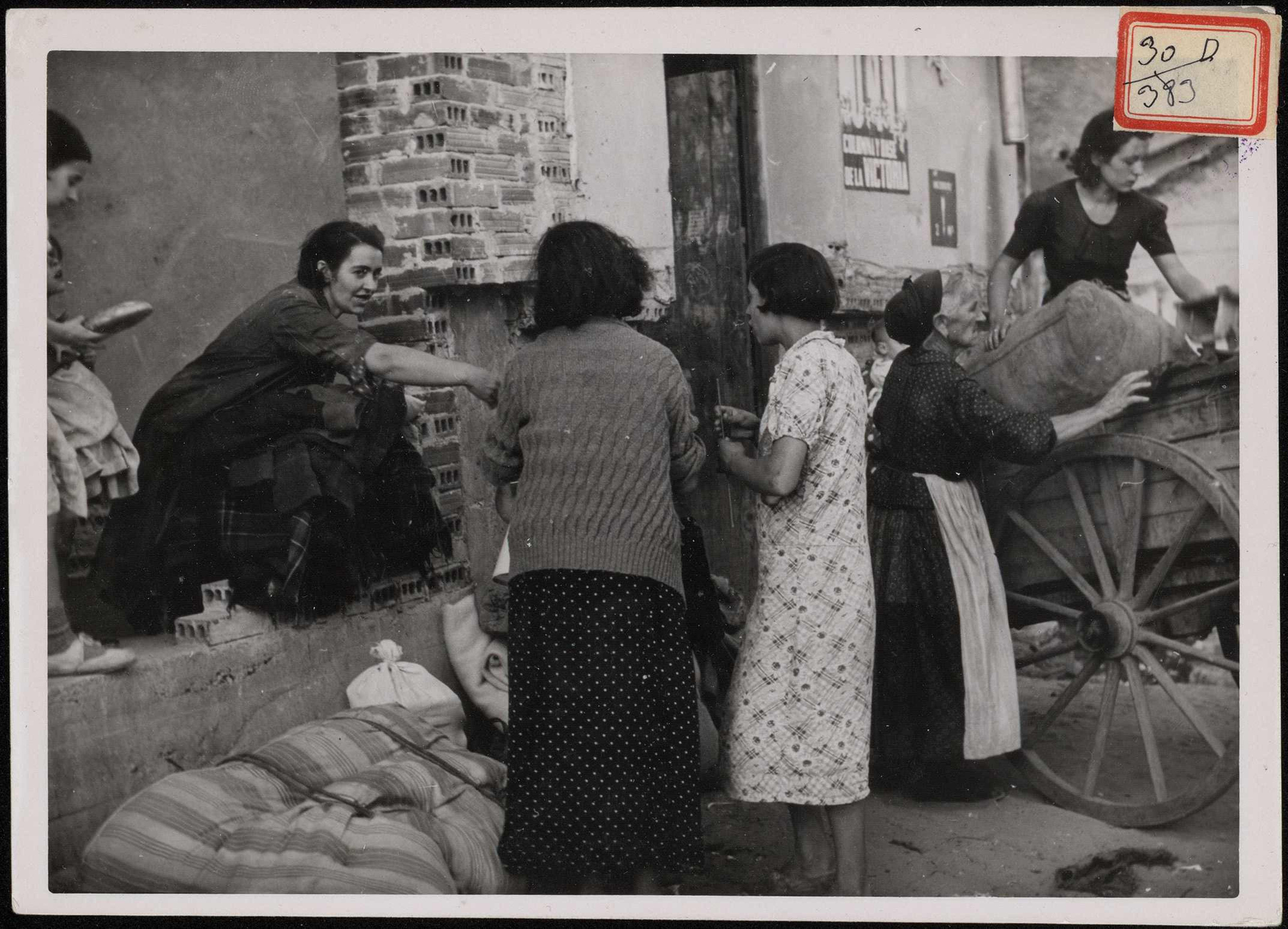 "Familias recogiendo sus ajuares para trasladarlas a sus casas de donde habían sido despojadas por los rojos". | Biblioteca Nacional de España