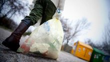 Un niño, a punto de reciclar una bolsa llena de briks y envases de plástico.