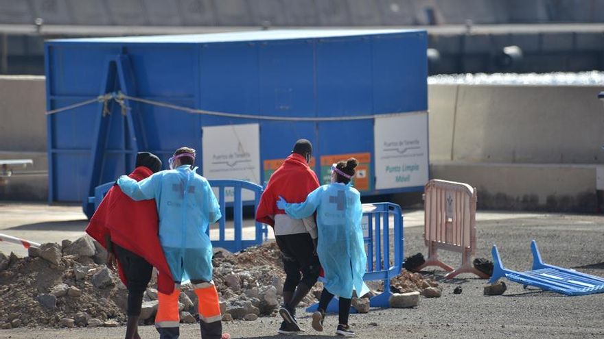 Personal de Cruz Roja atiende a dos de las 50 personas llegadas al puerto de La Estaca, en el Hierro, tras ser rescatadas por Salvamento Marítimo.