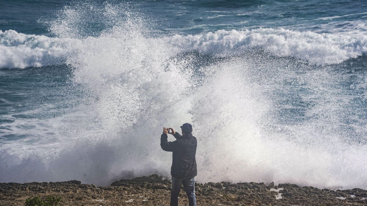 Un hombre realiza una fotografía del temporal en Menorca.