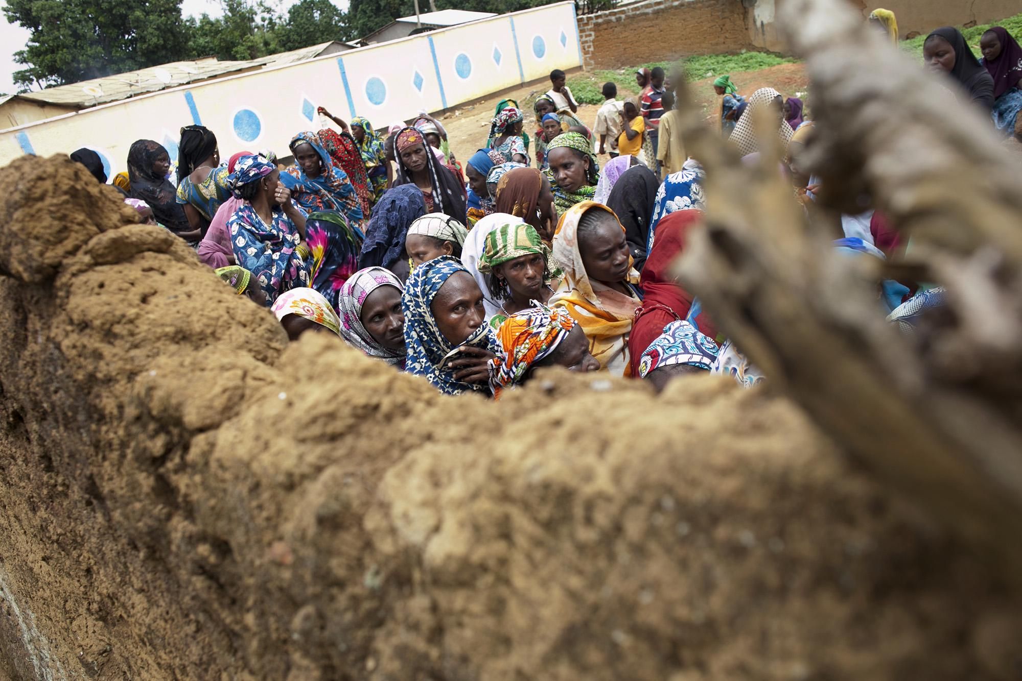 Mujeres refugiadas hacen cola frente a la sede de una organización humanitaria local esperando la distribución de comida y ropa. El trabajo de estas organizaciones locales es vital para asegurar la atención a los miles de refugiados que no están bajo tutela de Naciones Unidas o que han preferido quedarse a vivir temporalmente en los barrios de Garoua Boulai, acogidos por familiares o vecinos que les han abierto las puertas de sus casas./Albert Masias