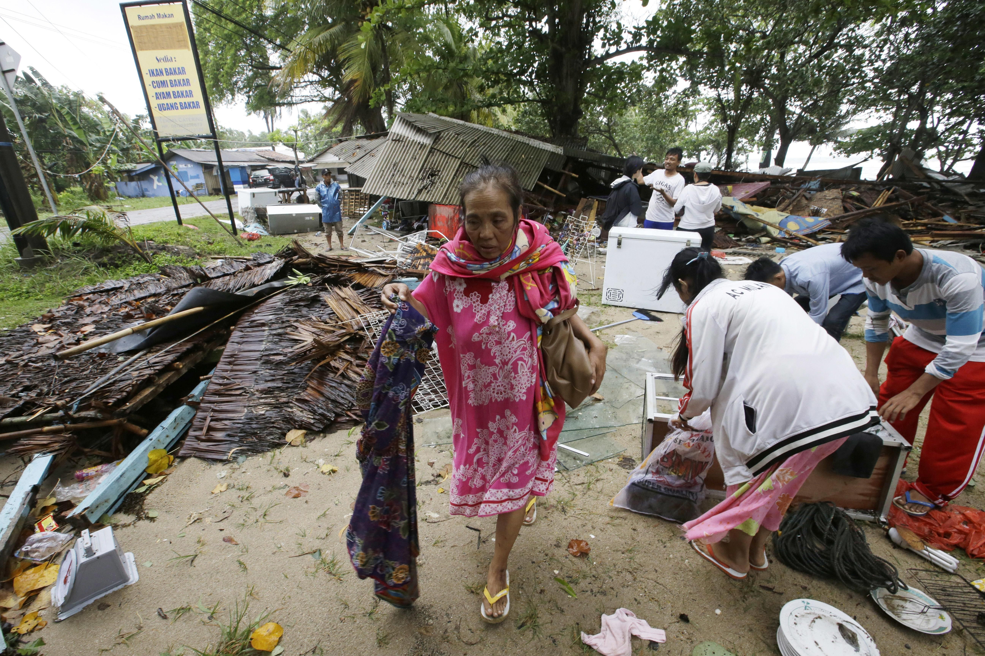 Una mujer inspecciona su casa, que fue dañada por el tsunami en Carita, Indonesia