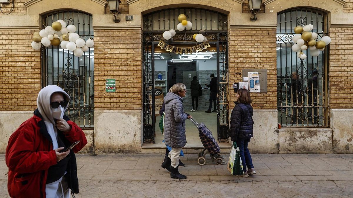 Varias personas pasan por un comercio de Paiporta semanas después de la DANA en una imagen de archivo.
