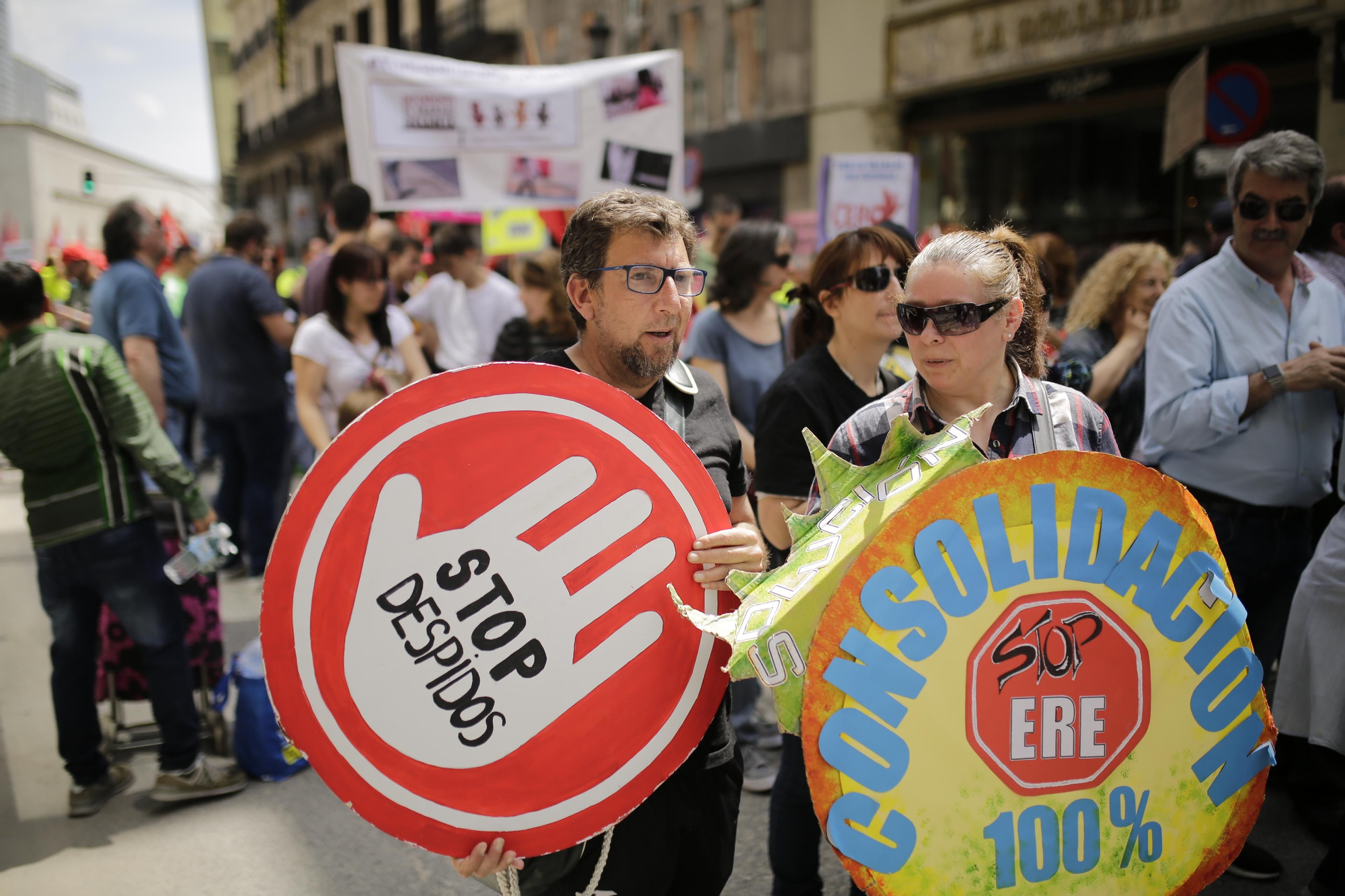 Dos manifestantes en Madrid con carteles contra los despidos y los ERE.