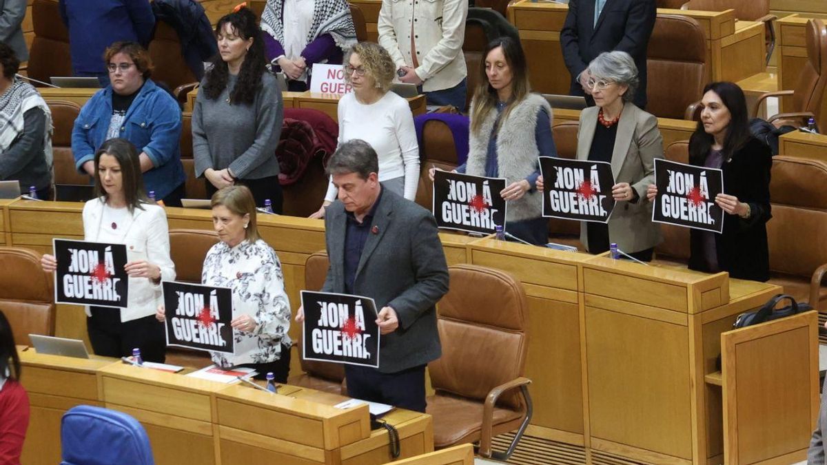 Los diputados socialistas en el Parlamento gallego sostienen carteles contra la guerra durante un minuto de silencio por las víctimas del 11M