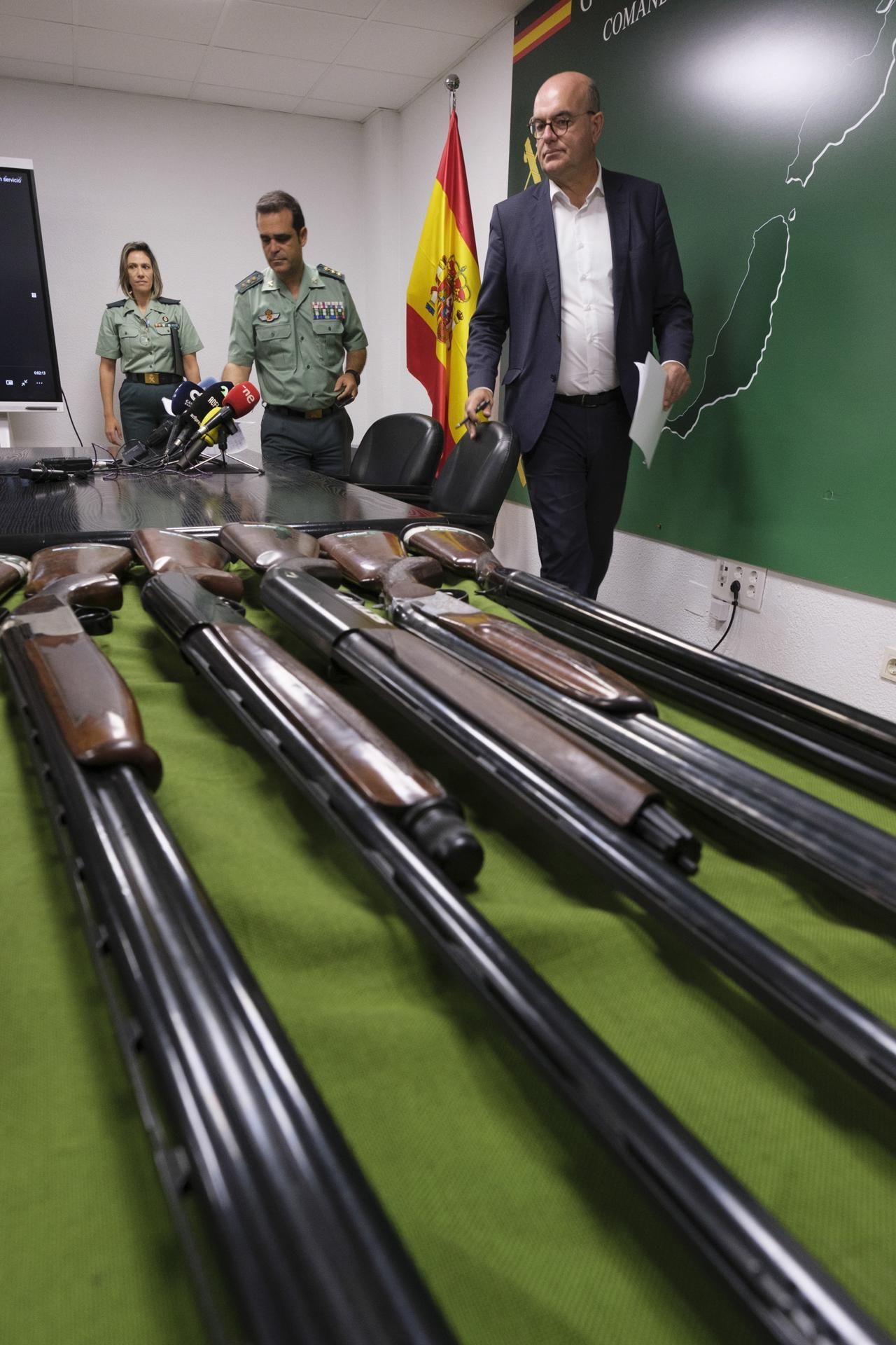 El delegado del Gobierno en Canarias, Anselmo Pestana (d), observa el arsenal intervenido, exhibido en la Comandancia de la Guardia Civil.