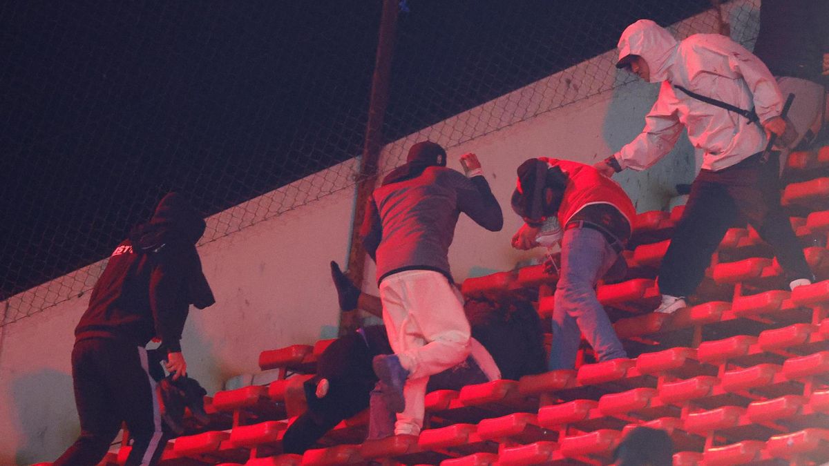 Hinchas se enfrentan en una tribuna en un partido de los octavos de final de la Copa Sudamericana entre Independiente y Universidad de Chile en el estadio Libertadores de América
