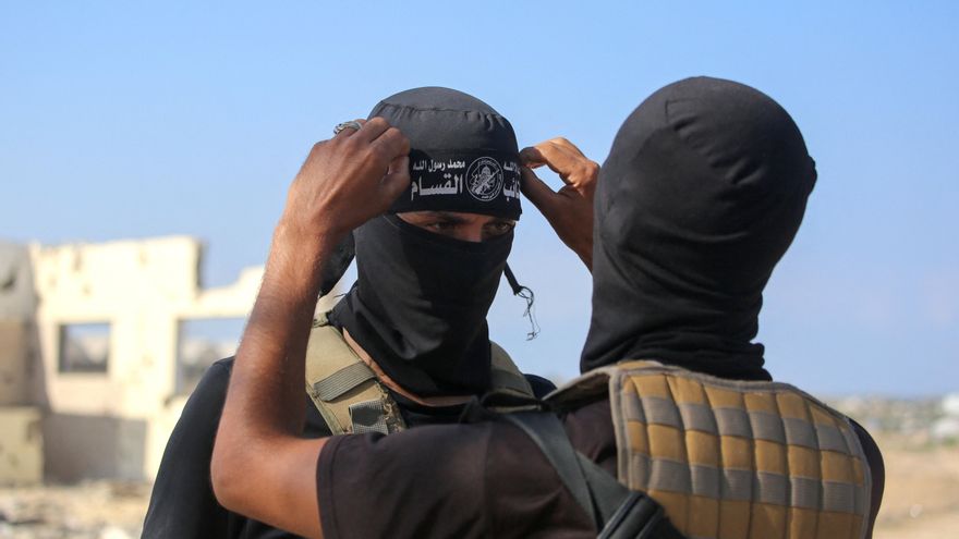 Dos miembros de las milicias de Hamás en la zona donde se produjo la liberación de rehenes israelíes el 13 de octubre en Deir el-Balah, Gaza.