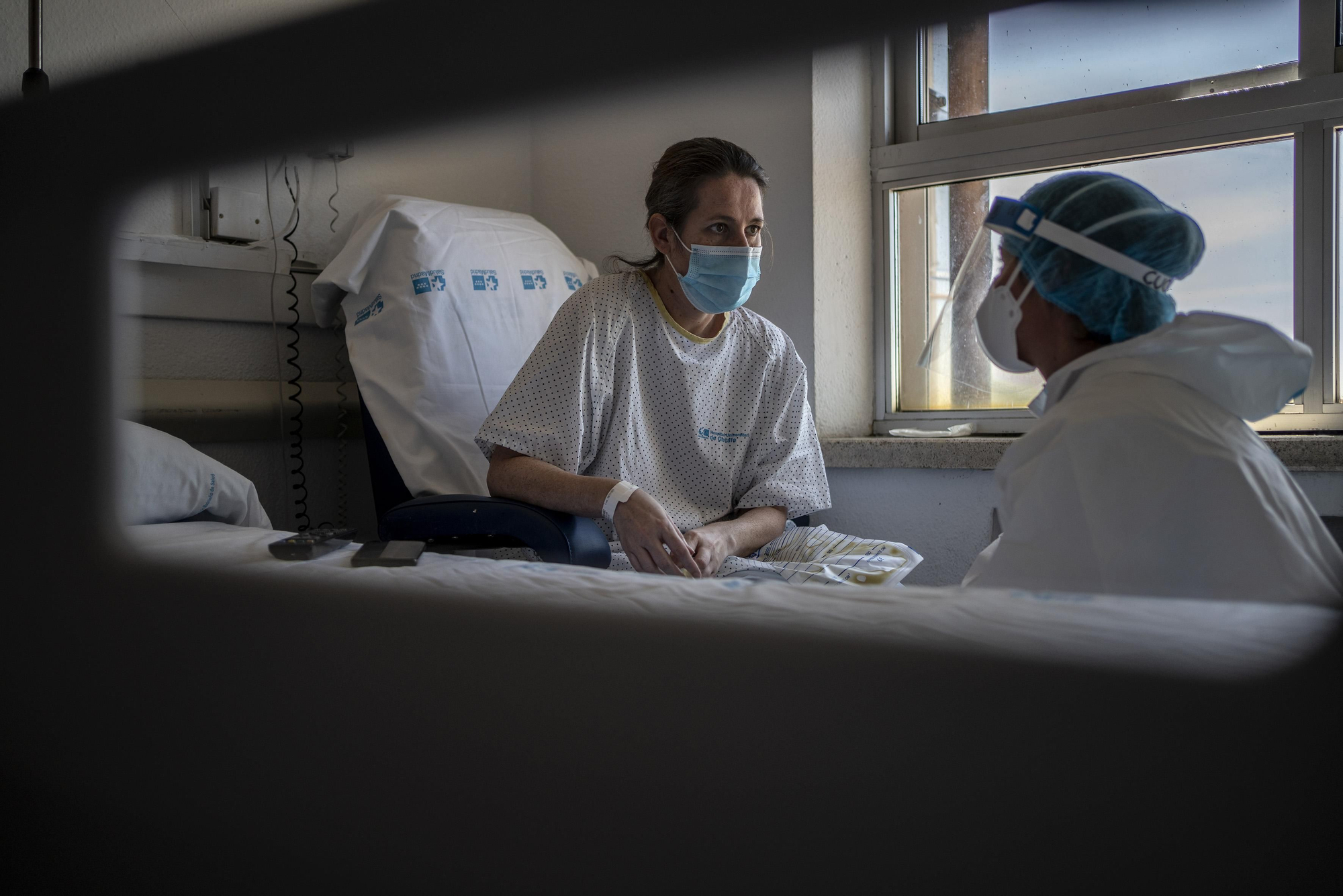 Lucía, técnico de cuidados, habla con Ana, una paciente de 41 años con COVID-19 que lleva semanas ingresada en el hospital.