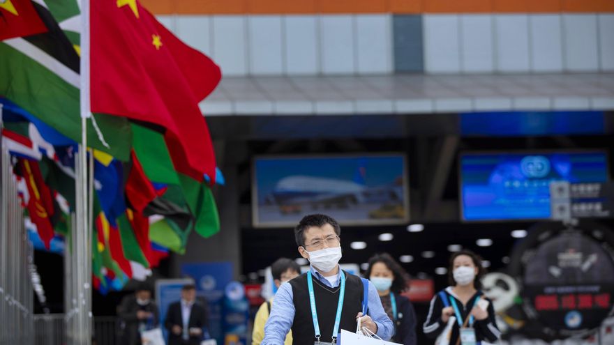 Los visitantes, protegidos con mascarillas,  caminan frente a la 3ª Exposición Internacional de Importación de China en Shanghai, China. EFE/EPA/ALEX PLAVEVSKI