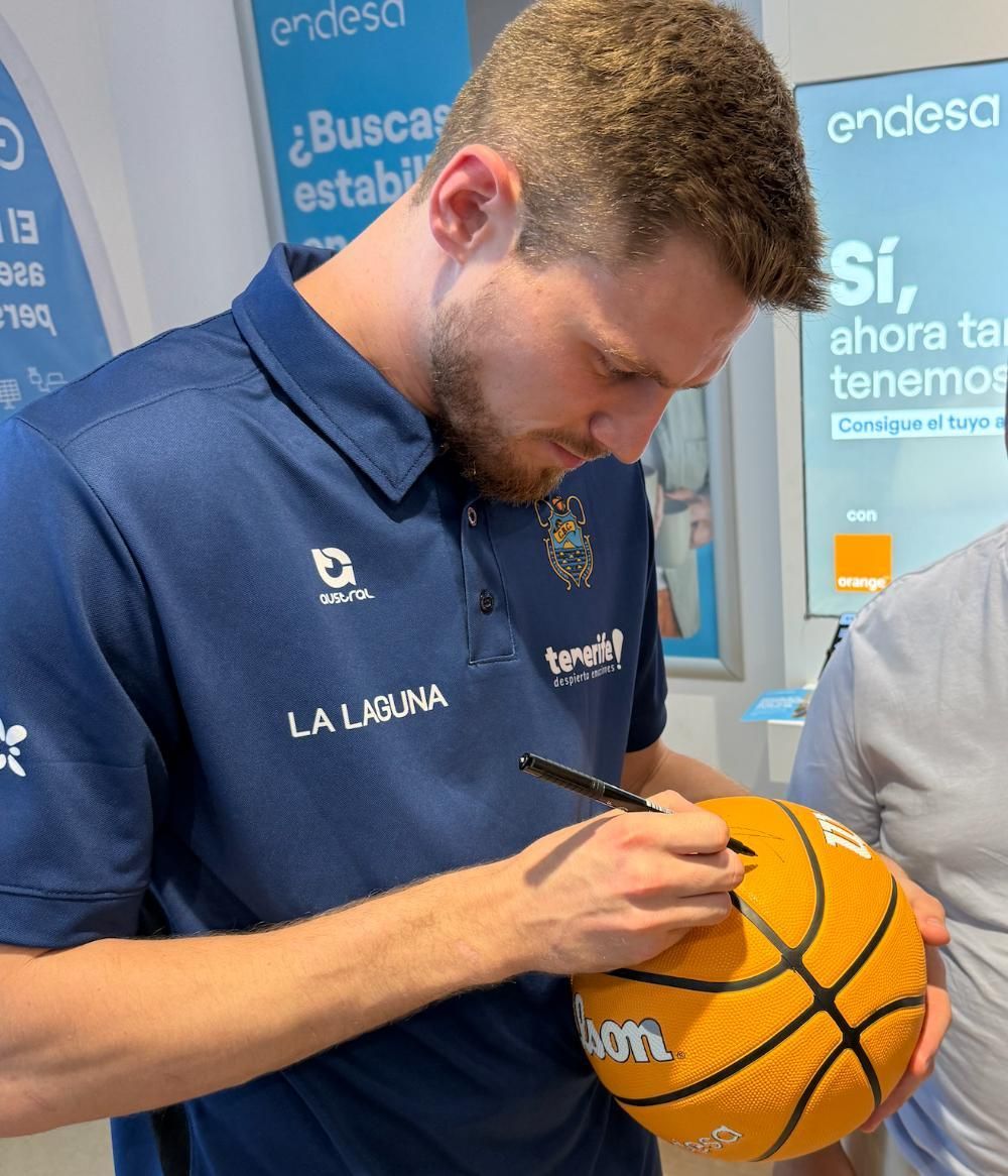 Jugadores del CB Canarias, con un aficionado en la tienda Endesa de Santa Cruz de Tenerife durante uno de los encuentros Meet and Greet.