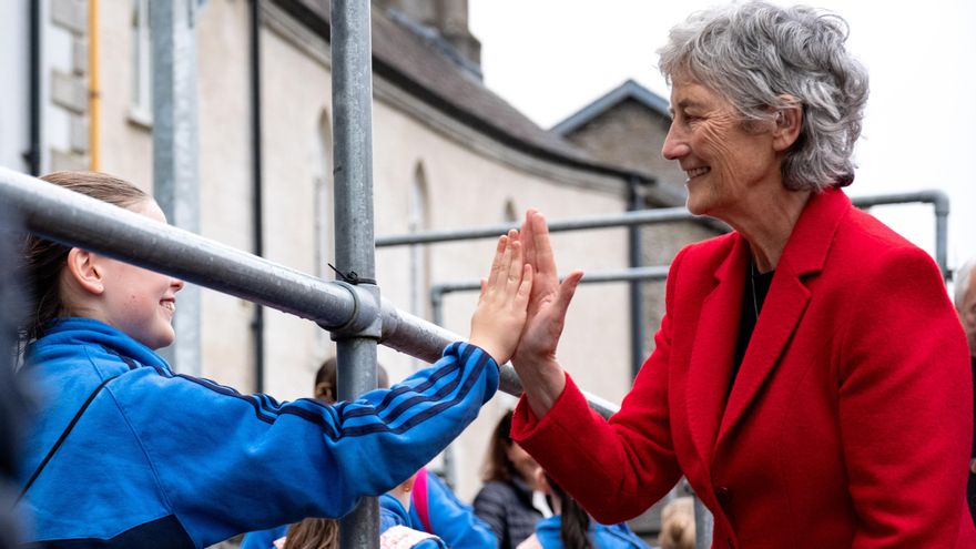 La presidenta electa de Irlanda, Catherine Connolly, choca los cinco a una niña en Naas, en el condado de Kildare, el 14 de octubre durante la campaña electoral.