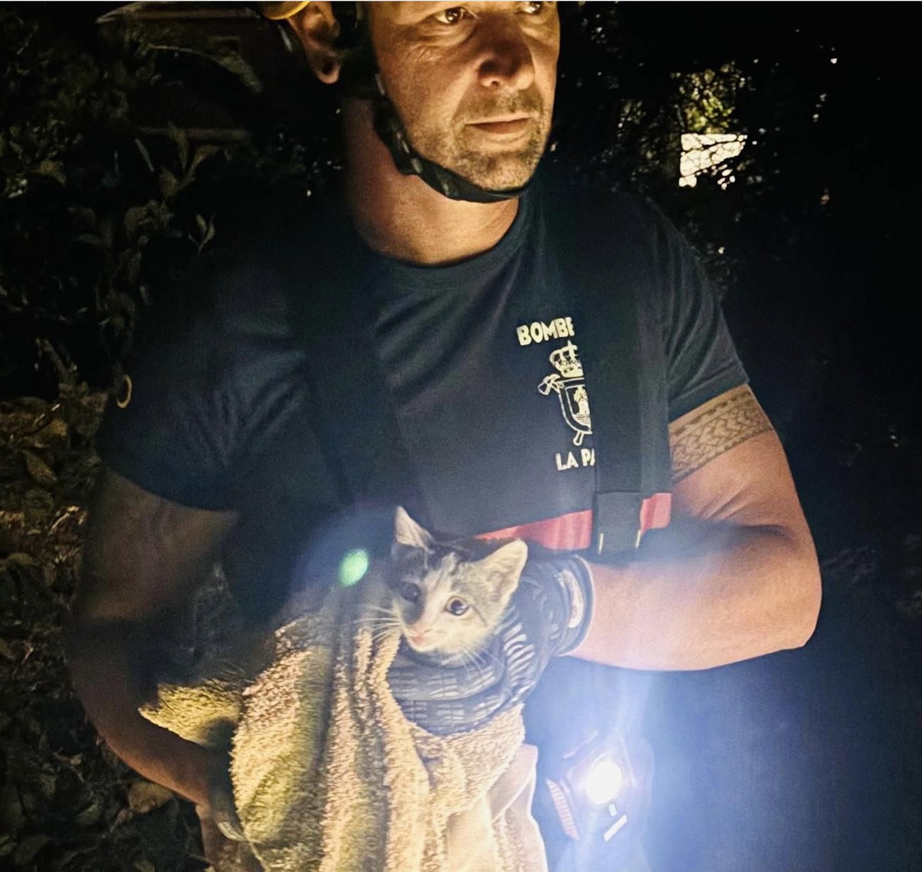 Un bombero con el gato rescatado en un estanque en El Paso.