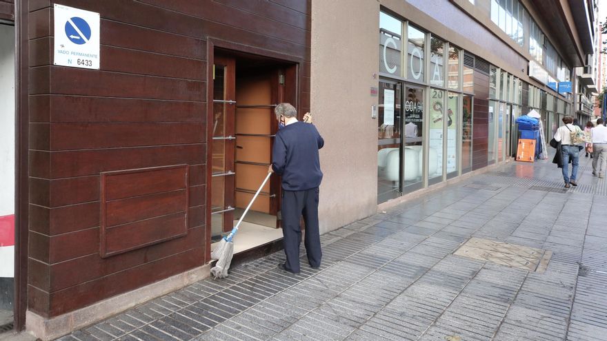 Un hombre limpia el acceso a un edificio tras las lluvias del miércoles