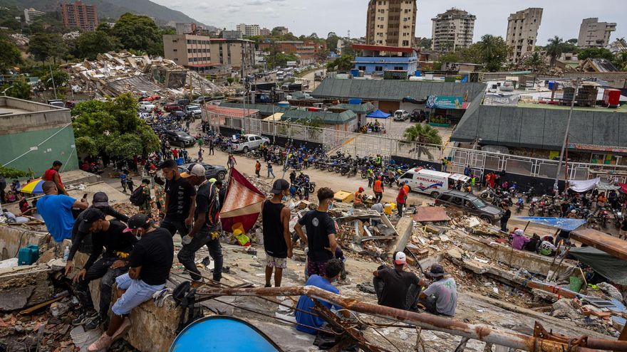 Personas observan edificios colapsados por los terremotos este martes, en La Guaira (Venezuela).