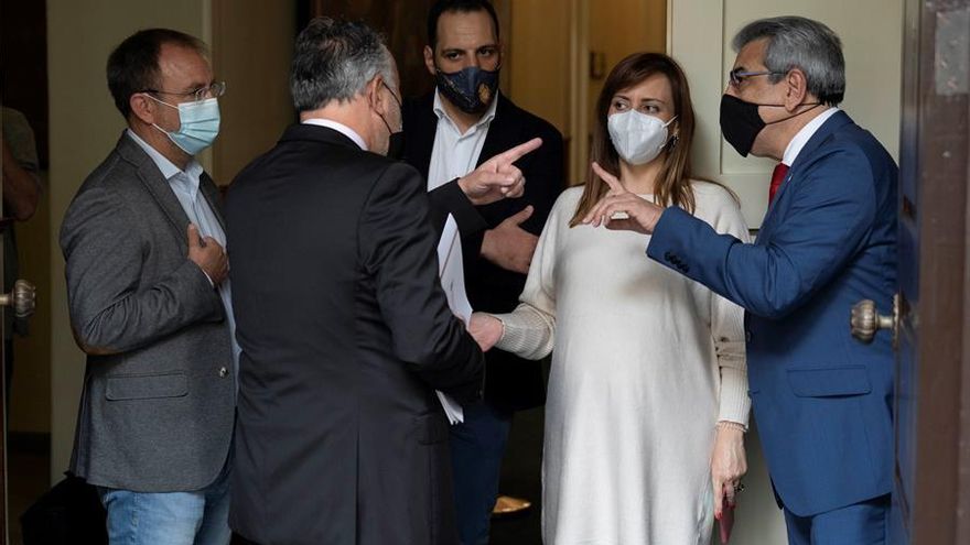 El presidente del Gobierno de Canarias, Ángel Victor Torres (de espaldas), el vicepresidente y consejero de Hacienda, Román Rodríguez (d) y la diputada del grupo parlamentario Nacionalista Canario Nieves Lady Barreto (2d), momentos antes del debate de los Presupuestos
