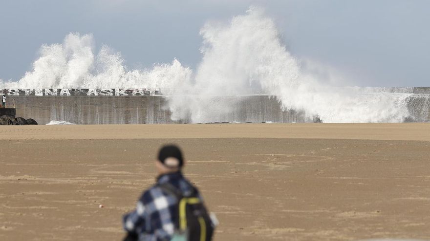 Un hombre observa las olas que este lunes han rebasado el rompeolas de la playa de Plentzia (Bizkaia)