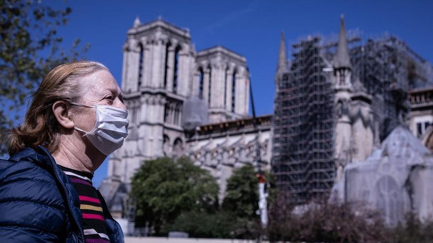 Mujer con mascarilla cerca de la catedral Notre Dame de París